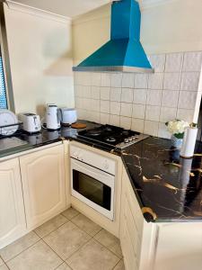 a kitchen with a stove and a blue hood at Affordable accommodation in Perth