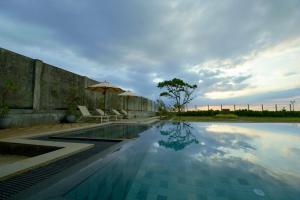 a swimming pool with two chairs and an umbrella at Agni Luxury Beach Villa in Olagama