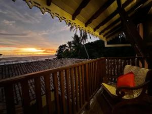 a balcony with a view of the beach at sunset at Agni Luxury Beach Villa in Olagama