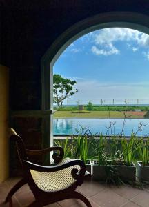 a chair in front of a window with a view of a lake at Agni Luxury Beach Villa in Olagama