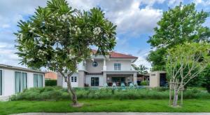 a house with two trees in front of it at Dudnapa Pool Villa Hua Hin in Hua Hin