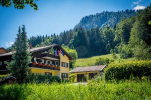 a building on a hill with trees in the background at Hotel Garni Zeranka in Ruhpolding