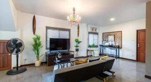 a living room with a couch and a flat screen tv at Dudnapa Pool Villa Hua Hin in Hua Hin