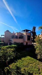 a house on a hill with a green yard at Votre Villa Soleil et Chaleureuse in Marrakesh