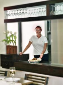Corinna Mare في كالاماكي: امرأة تقف في مكتب مع طبق من الطعام