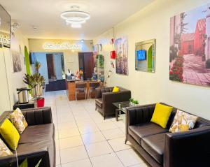 a waiting room with leather couches and yellow pillows at Bon Repos Arequipa in Arequipa