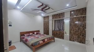 a bedroom with a bed and a mirror at Kutir Stay Aaram in Secunderabad