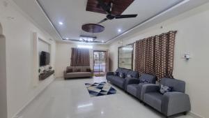 a living room with a couch and a tv at Kutir Stay Aaram in Secunderabad