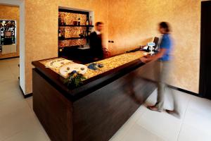 a woman is standing at a counter in a kitchen at VRclub - Villa Ridente Residence in Gioiosa Marea