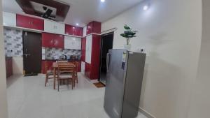 a kitchen with red cabinets and a stainless steel refrigerator at Kutir Stay Aaram in Secunderabad