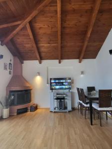 een woonkamer met een tafel, een tv en een open haard bij skyview house in Delfoi