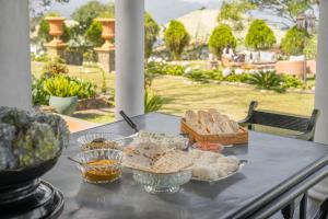 a table with bread and other food on it at Garfield Bungalow by TONIK - 4BR Private Bungalow in Haputale - Mountain Views in Haputale