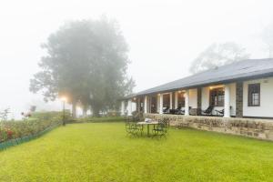 a house with a table and chairs in a yard at Garfield Bungalow by TONIK - 4BR Private Bungalow in Haputale - Mountain Views in Haputale +20 photos