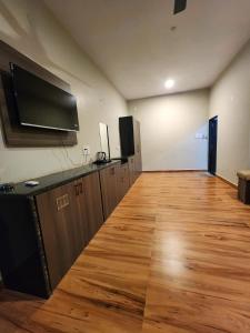 a large room with a wooden floor and a flat screen tv at Khatiya Camp in Mandlā