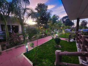 a park with palm trees and a sidewalk with lights at Khatiya Camp in Mandlā