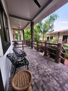 a porch with two chairs and a table and a fence at Khatiya Camp in Mandlā