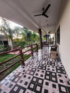 a porch with a ceiling fan and a fence at Khatiya Camp in Mandlā
