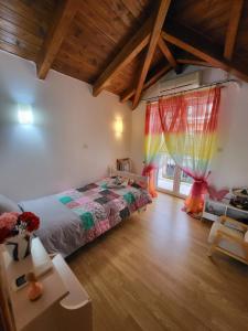 een slaapkamer met een bed in een kamer met houten vloeren bij skyview house in Delfoi