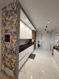 een keuken met witte kasten en een tegelvloer bij I MORI Alloggio turistico in Civitavecchia +32 foto's