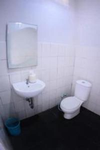 een badkamer met een wit toilet en een wastafel bij FX 72 Ruteng Hotel in Ruteng