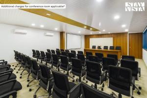 an empty lecture room with black chairs and a podium at StayVista at Thalassa Near The Beach in Alibaug