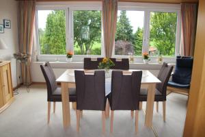 a dining room with a table and chairs and windows at Ferienwohnung Katzan in Ebstorf