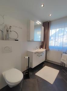 un bagno bianco con un water e un lavandino di das Alpenblick & Outdoor Lodge Nauders a Nauders Altre 83 foto