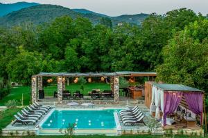 a swimming pool with chairs and a gazebo at Levantes Villas in Kala Nera