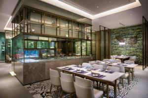 een eetkamer met tafels en stoelen en een keuken bij Wanda JIN Baise in Qitang