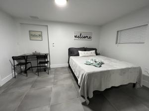 een slaapkamer met een bed, een tafel en een bureau bij LYZ Miami Airport in Miami