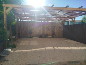 a wooden pergola with the sun shining behind it at Casita acristalada con jacuzzi in Tiñosa Alta +13 photos