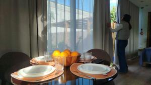 a woman taking a picture of a table with a bowl of fruit at Casita acristalada con jacuzzi in Tiñosa Alta
