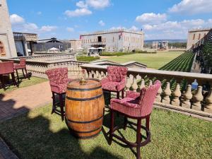 a group of chairs and a barrel on a patio at Castle de Wildt in Modimolle