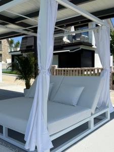 a canopy bed with white sheets and pillows at Lagarteira in Sanxenxo