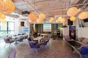 een lobby met stoelen, tafels en verlichting bij Swiss-Grand Beach Resort Kuantan in Kuantan