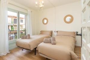 deux lits dans une chambre avec fenêtre dans l'établissement Calma de Mar en Palamós, à Palamós