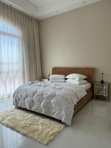 a white bedroom with a large bed and a window at The Moonridge Retreat in Sinādil