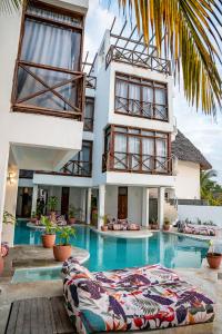 ein Haus mit einem Swimmingpool vor einem Gebäude in der Unterkunft ZAN Tropical Jambiani Beach in Bwejuu
