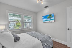 a white bedroom with a bed and a window at The Bungalows in St. Pete Beach +98 photos