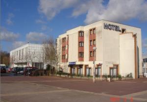 a white building with a hotel on the side of it at Hipotel Paris Marne La Vallée in Noisiel