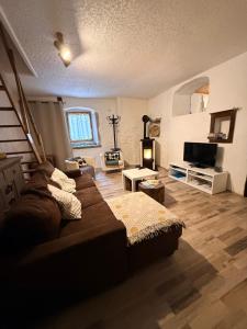 un salon avec un canapé et une télévision dans l'établissement Gîte des reculées, à Ladoye-sur-Seille