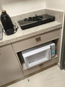 un piano di lavoro con un forno a microonde e un fornello di Pé na Areia a João Pessoa