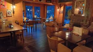 a restaurant with wooden tables and chairs and windows at Private Chalet Heppie People in Doornspijk +13 photos