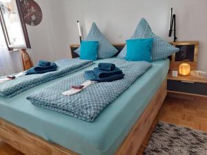 una camera con 2 letti con cuscini e asciugamani blu di Merziger Fußgängerzone a Merzig
