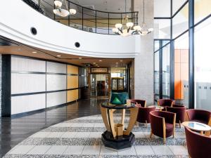 een lobby van een hotel met stoelen en een tafel bij APA Hotel Kagadaishoji Ekimae in Kaga +34 foto's