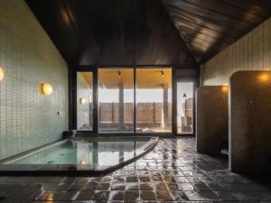 een zwembad in een gebouw met uitzicht bij APA Hotel Kagadaishoji Ekimae in Kaga