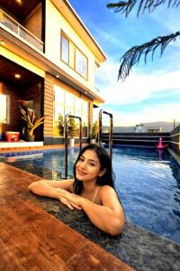 een vrouw op de rand van een zwembad bij ll EMPYREAN STAYS ll G0DFATHER VILLA ll MINI PUB ll 4BHK ll AC ll LARGEST POOL ll in Lonavala