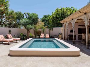 a swimming pool in a patio with a table and chairs at Yellowtail Finca in Plettenberg Bay