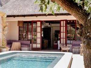 a swimming pool in front of a house at Yellowtail Finca in Plettenberg Bay