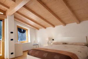 een slaapkamer met een groot bed en een raam bij Appartamento Mary - Casa Green - Dog friendly, box auto in Cogolo